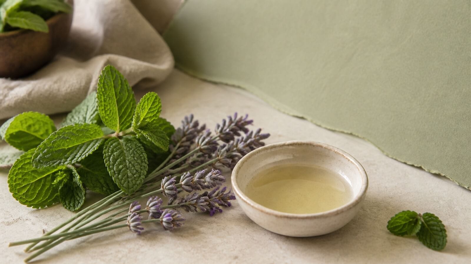 eteriska-oljor-huvudvark-migran Pepparmynta och lavendel med utspädd aromablandning på sval sten