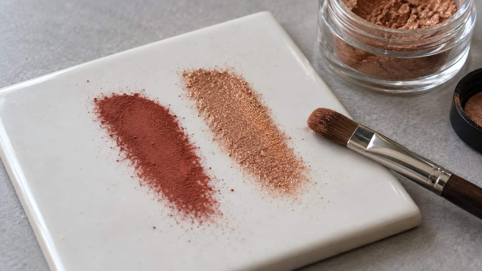 mineralpigment mica matta skimrande prov Matt rostrött pigment och skimrande bronsmica som tunna prov på en vit platta